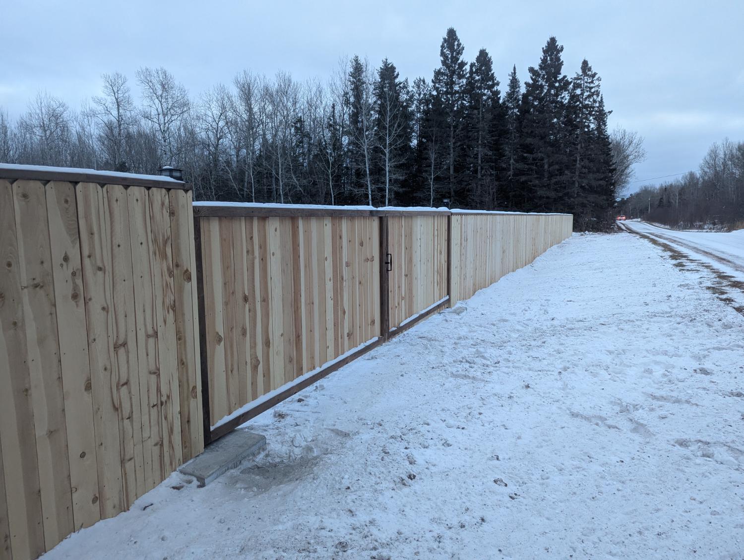 Long wooden fence in winter landscape