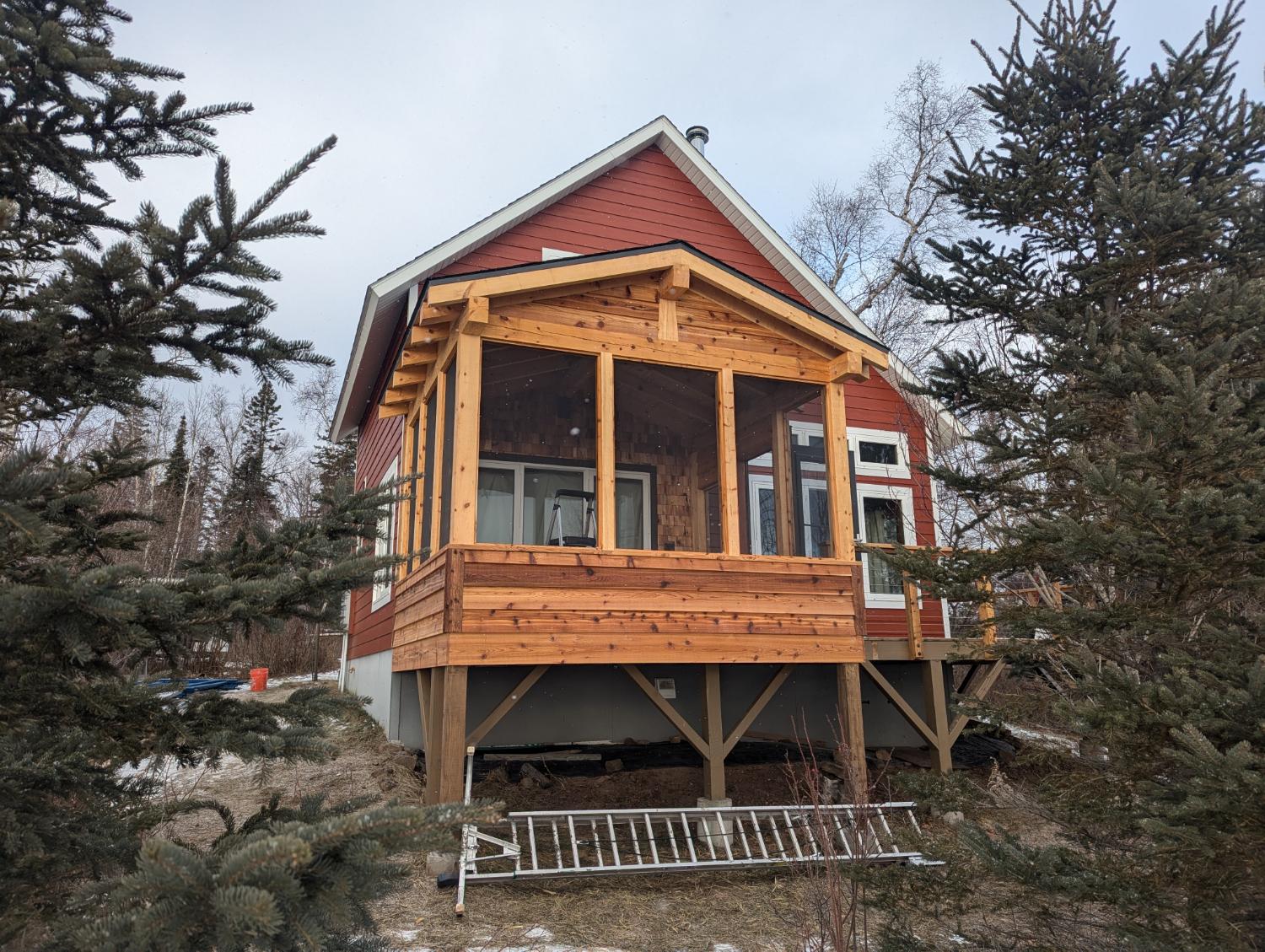 Red home with large screened porch on stilts
